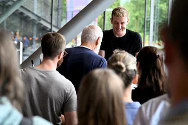 Édouard Louis at the autograph session after the event. Many people are standing around him waiting for an autograph.