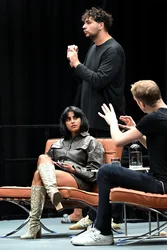 Jahrhunderthalle Bochum: View of the stage at the ‘Brave New Voices’ event. The presenter Fatima Khan and the writer Édouard Louis can be seen. Next to them is an interpreter translating into German sign language.