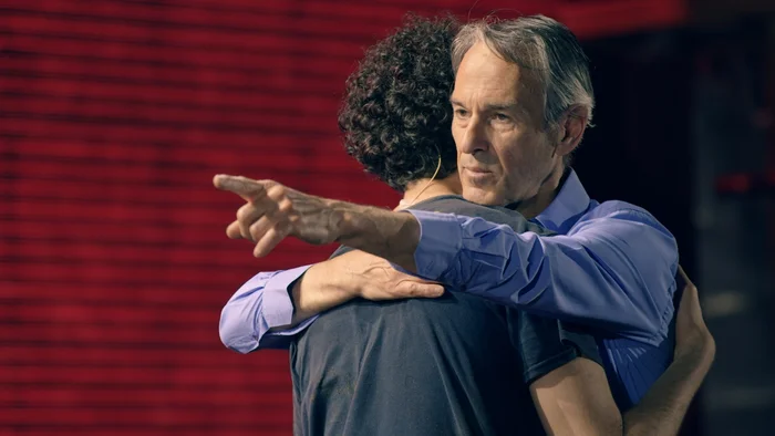 Ivo Van Hove umarmt eine Person.