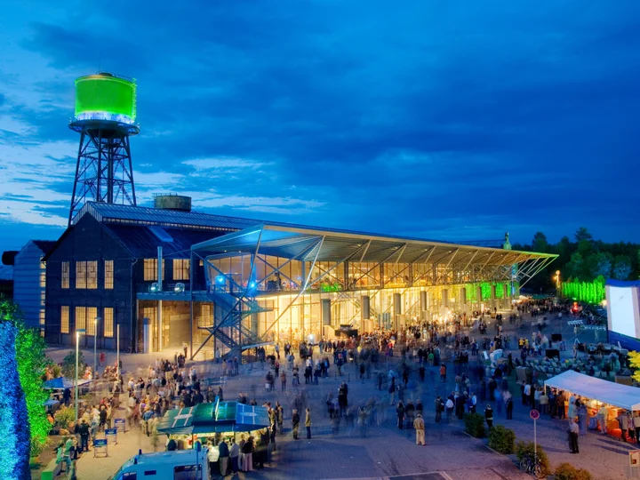 Jahrhunderthalle Bochum bei Dämmerung mit Publikum auf dem Vorplatz