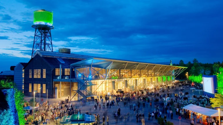 Jahrhunderthalle Bochum bei Dämmerung mit Publikum auf dem Vorplatz